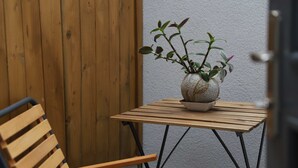 A wooden chair and a small table with a potted plant. - The Macaron Poyraz Guesthouse (Ayvalik)