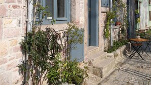 A building with a sign for 'The Macaron PoYraz - Guest House' and a cobblestone street. - The Macaron Poyraz Guesthouse (Ayvalik)