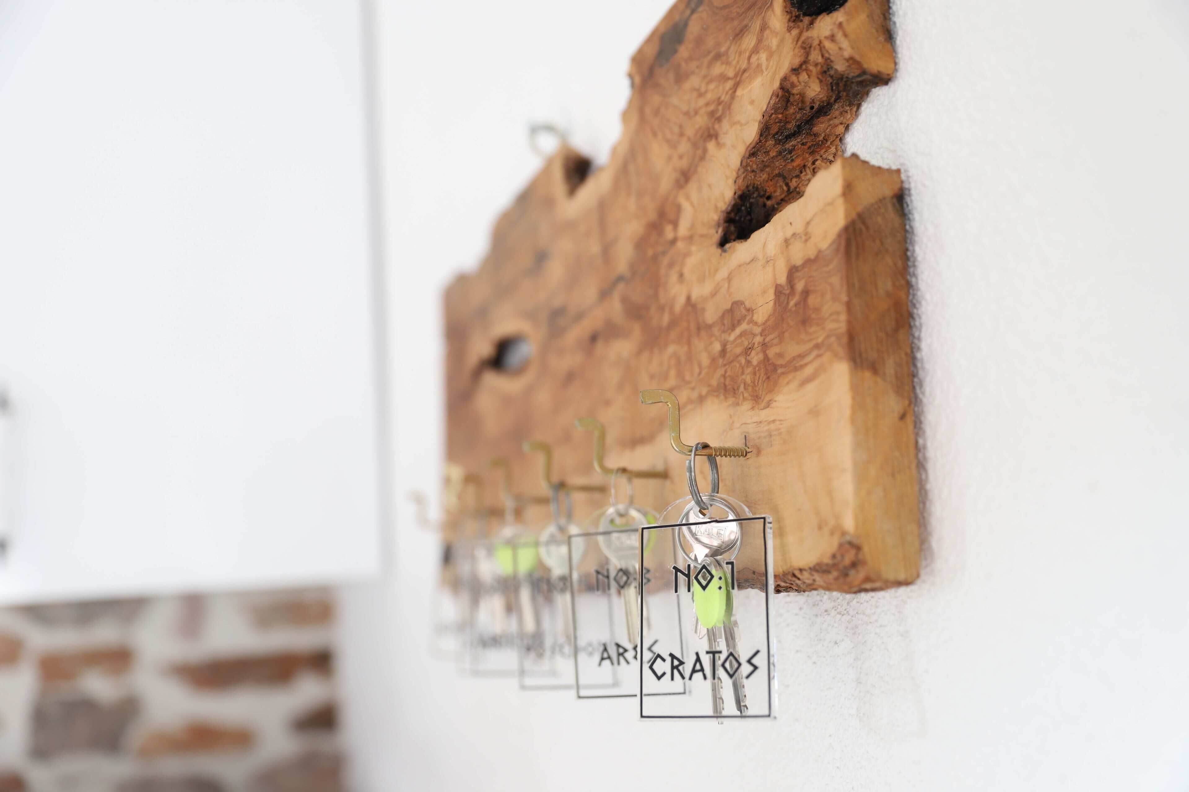 A wall-mounted wooden structure with keys hanging from hooks.