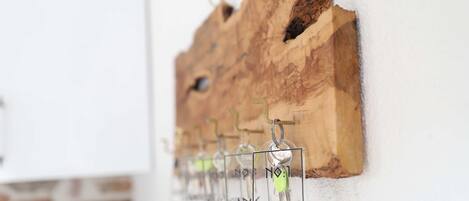 A wall-mounted wooden structure with keys hanging from hooks.