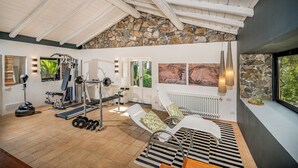 A spacious room with a stone wall, a large window, and a ceiling with wooden beams. - Linera 10, Emma Villas (Linera)
