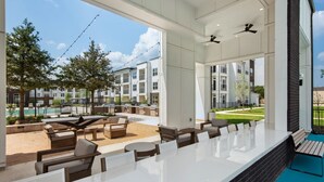 Un área de patio al aire libre con asientos y vista a la piscina.