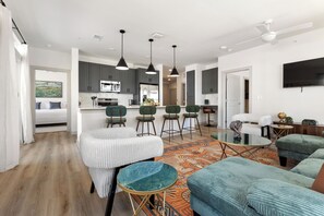 A modern living room with a sofa, a coffee table, and a TV mounted on the wall.