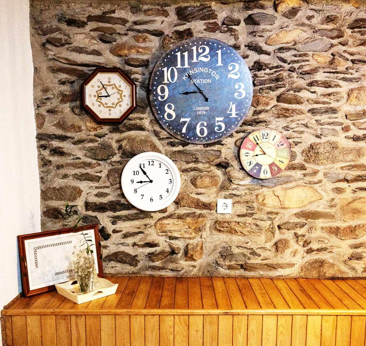 Un mur de pierre orné de quatre horloges de styles et de modèles différents.