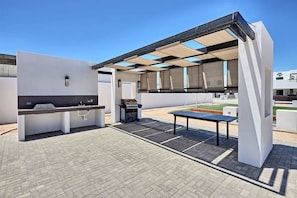 An outdoor patio area with a grill, a sink, and a table. - Contemporary In-Town Home with Pool Casa Cactus (Puerto Peñasco)