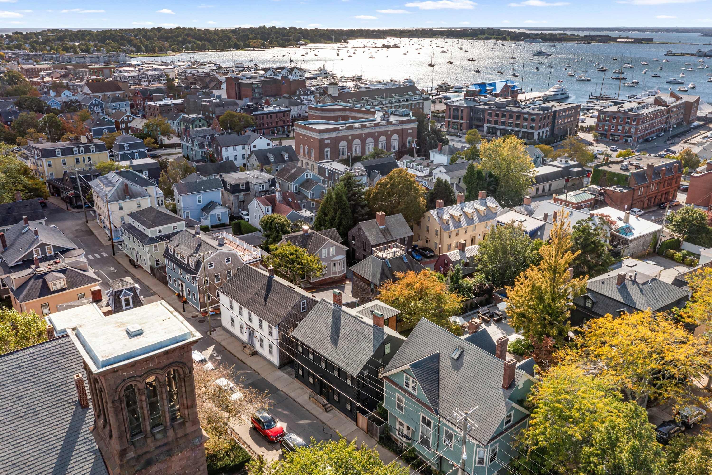 An aerial view of a coastal town with historic buildings, a marina, and boats.
