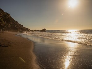 A beach with a rocky coastline and the sun reflecting off the water. - CHL Mayoysa Vista mar en Bre a Baja La Palma (Brena Baja)