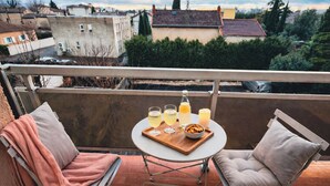 A balcony with two chairs, a table, and a tray with drinks and snacks. - Douce parenthèse - T2 Cosy & warm Montélimar station center within walking distance (Montélimar)