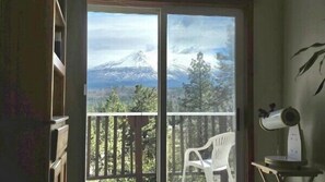 A room with a sliding glass door leading to a balcony with a view of a mountain. - 30 Night Minimum, Shasta View Villa (Weed)