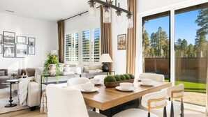 A modern living room with a dining area, large windows, and a view of the outdoors. - Modern*Fully Fenced Yard*A/C* Near Forest (Flagstaff)