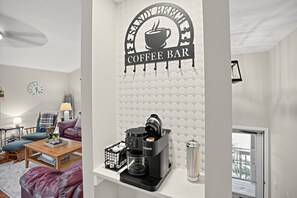 Ein modernes Wohnzimmer mit einer Kaffeebar, einer Uhr und einem Sofa.