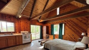 A cozy cabin with a kitchen, a dining area, and a large bed. - 30 Night Minimum, Shasta View Chalet (Weed)