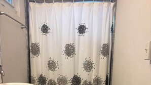 A small bathroom with a white sink, toilet, and shower curtain with a floral pattern.