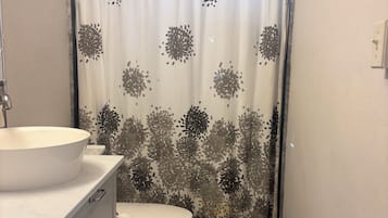 Chuveiro, toalhas de banho, sabonete, shampoo