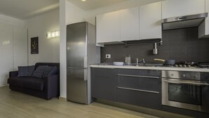 A modern kitchen with stainless steel appliances, white cabinetry, and a built-in oven. - Welcome to Bari Sky Terrace (Bari)