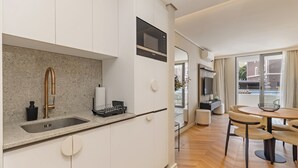 Eine moderne Küche mit weißen Schränken, einer Granitarbeitsplatte und einer Spüle aus Edelstahl.