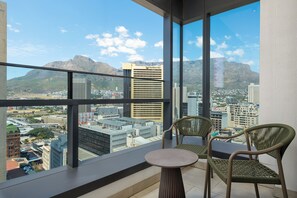 Un balcon offrant une vue sur la ville et les montagnes.