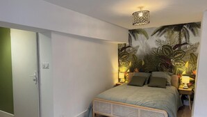 Une chambre à coucher avec un lit, une porte, une peinture murale et un luminaire au plafond.