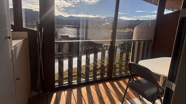 Ein Balkon mit Blick auf Berge und einen See.