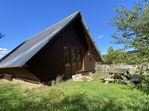 A wooden cabin with a sloped roof, a wooden door, and a small porch area. - Chalet, pets allowed, view of arenas (Le Vernet)
