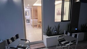 A modern outdoor seating area with metal chairs and a patterned floor. - Aerobeach Apartments (Cartagena de Indias)