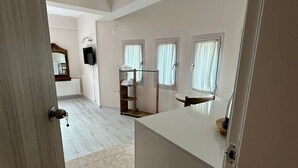 Un interior moderno con un mostrador de recepción blanco, una puerta de madera y un suelo de baldosas.
