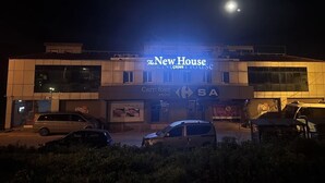 Un edificio con un cartel que dice "The New House" y "Carrefour Mini".