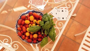 A table with a bowl of fruit, playing cards, and a newspaper. - Room-terrazza del Sole - Camera Maestral (Positano)