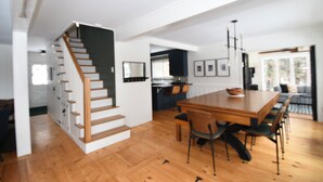 Un intérieur moderne comprenant un escalier, un coin repas et une cuisine.