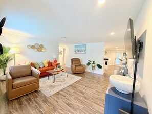 A living room with a sofa, armchair, coffee table, and a TV. - Salt water beach/City vibe vacation home. (Largo)