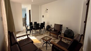 Un salon moderne avec un coin repas, comprenant des canapés, des fauteuils et une table basse.