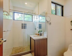 A modern bathroom with a glass shower enclosure, a wooden vanity, and a window providing natural light. - "La Chula" Fantástica Mansión de Lujo by TopSpot® (La Vega Arriba)