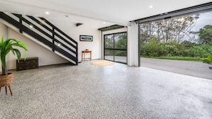 A spacious interior with a staircase, a large window, and a potted plant. - 3 Bedrooms Vista Point Sanctuary (Burleigh Heads)