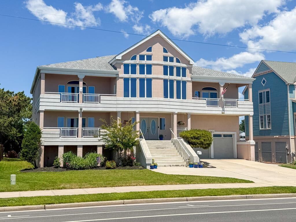 A two-story house with a balcony, a front porch, and a driveway.