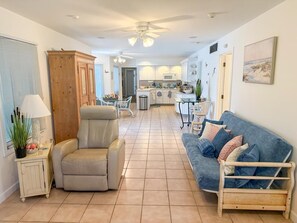 Ein Wohnzimmer mit Sofa, Sesseln und einem Essbereich mit Tisch und Stühlen.