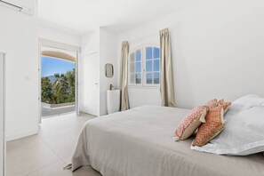 A bedroom with a bed, curtains, a window, and a view of greenery. - DAVIA - 5 bedrooms, 1 flat, panoramic sea view, swimming poo (PORTICCIO)