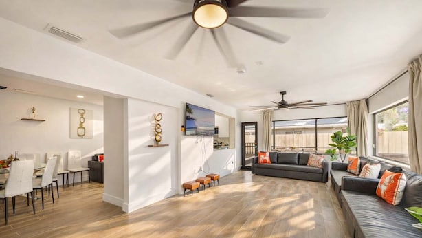 A spacious living area with a dining table, sofas, and a TV. - Versace Vibes Retreat, Pool Sauna Near Hard Rock (Hollywood)