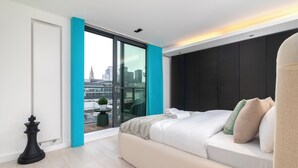 Ein modernes Schlafzimmer mit einem großen Bett, Blick auf die Stadt und einem Schachfiguren auf dem Boden.