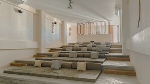 Ein modernes Interieur mit gestaffelten Sitzplätzen, einem Projektor und minimalistischem Design.