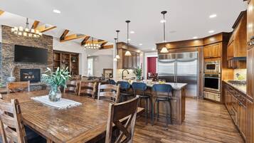 Una cocina amplia con electrodomésticos modernos, un comedor con mobiliario de madera y una chimenea de piedra.