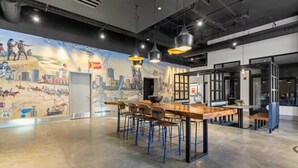 A modern bar area with a mural, bar stools, and pendant lighting. - Designer Apt: Walk to Busch Stadium, Free Parking (St. Louis)