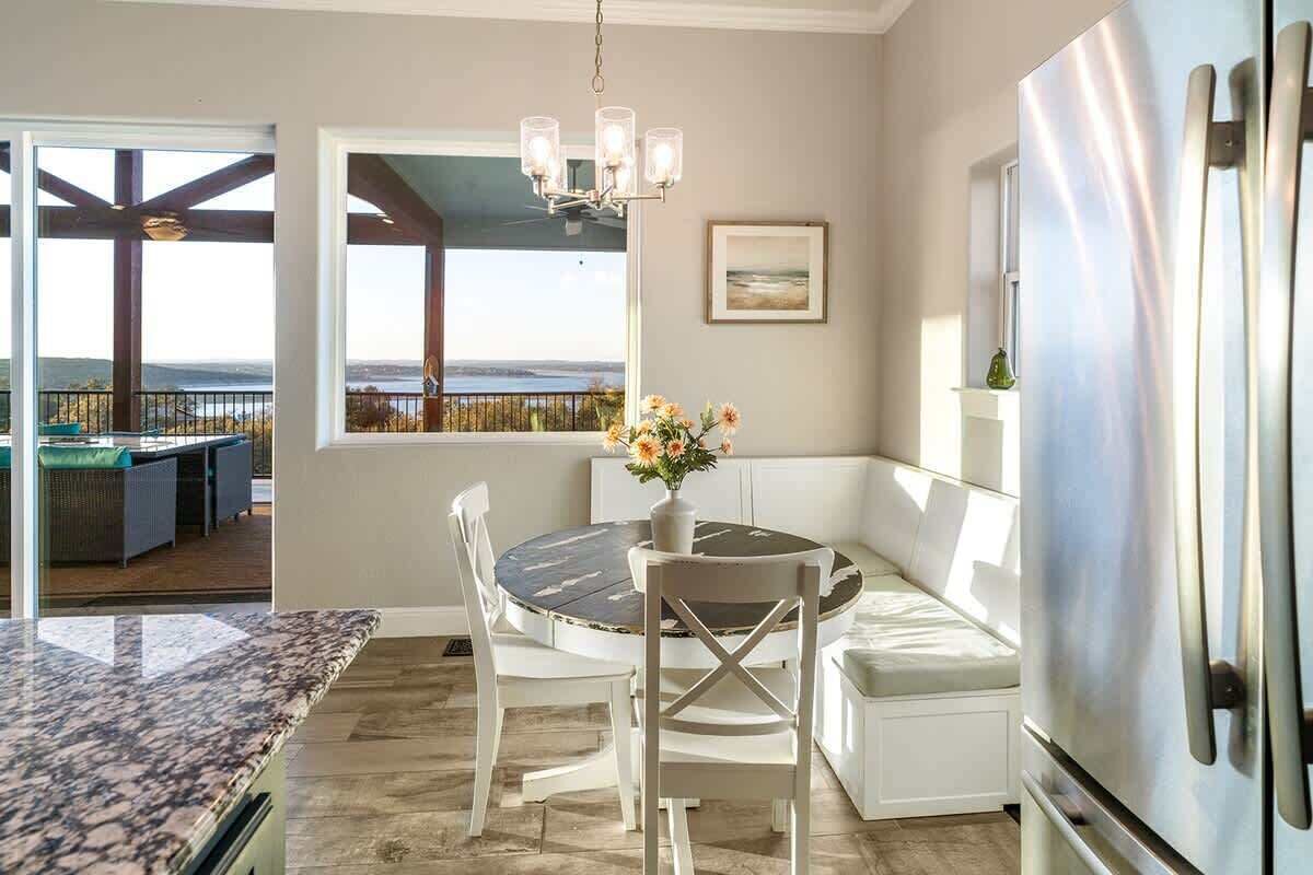 A kitchen with a dining area, a refrigerator, and a view of the outdoors.