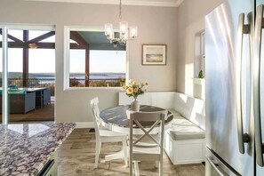 A kitchen with a dining area, a refrigerator, and a view of the outdoors.