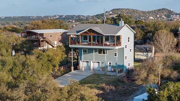 A two-story house with a balcony, a garage, and a driveway.