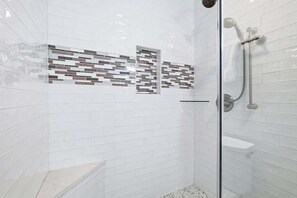 A shower with a glass door, white tiled walls, and a tiled shower area. - Beachfront, Decks, Cloud Nine, Sleeps 12, 30A (Inlet Beach)