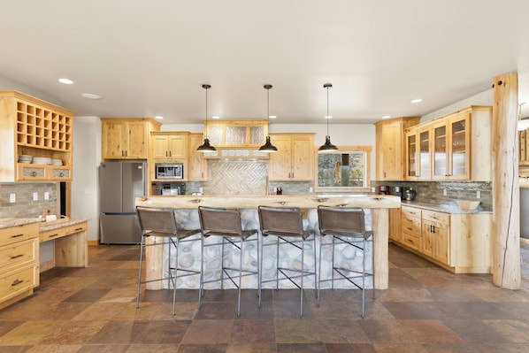 Una cocina moderna con una isla central, taburetes de bar y muebles de madera.
