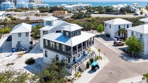 Un quartier résidentiel en bord de mer, avec des maisons modernes, une plage et une vue dégagée sur l’océan.