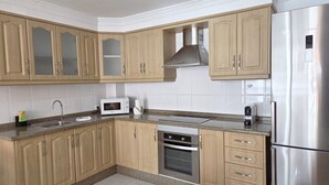 A kitchen with wooden cabinets, a stainless steel refrigerator, a microwave, and an oven. - Naos Costa Atlantica - Puerto Naos (Puerto Naos)