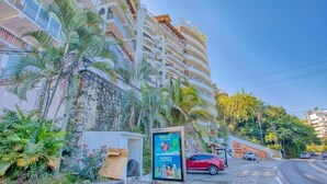 A multi-story hotel with balconies, palm trees, and a signboard. - Department Pino Amapas (Puerto Vallarta)