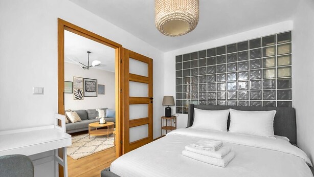 A modern hotel room with a large bed, a desk, and a sofa. - Mokotów Urban Cozy Apartment (Warszawa)